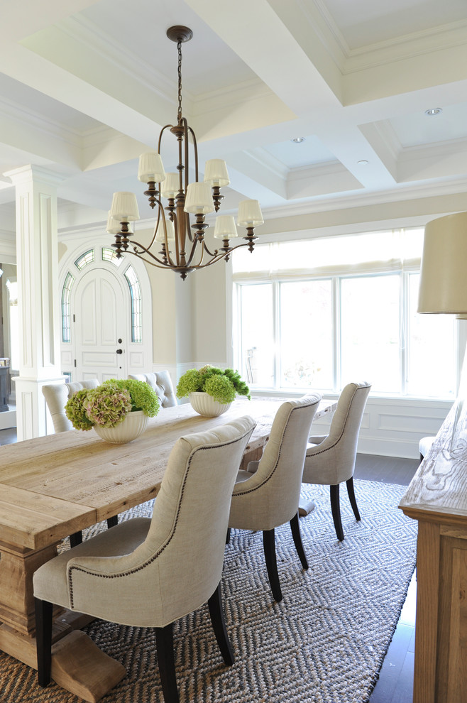 Design ideas for a traditional dining room in Vancouver with beige walls and brown floor.