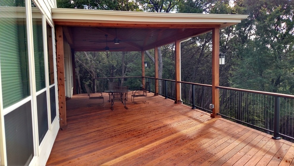 Photo of an expansive country backyard deck in Austin with a roof extension.