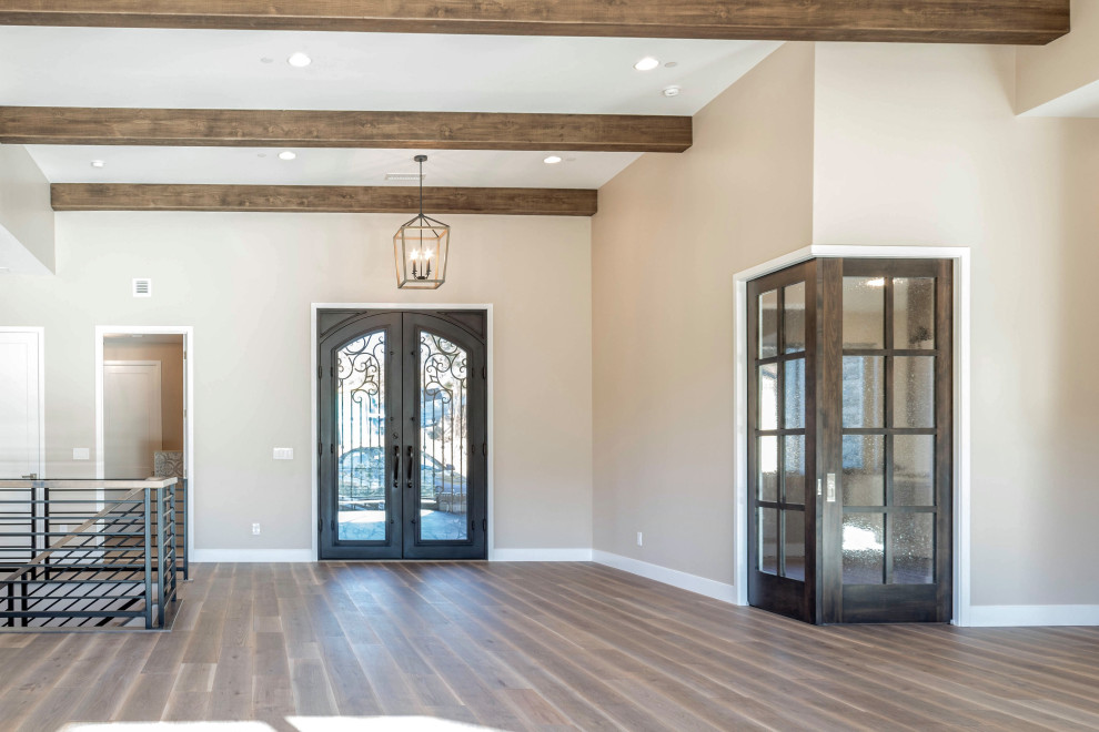 Große Urige Haustür mit beiger Wandfarbe, braunem Holzboden, Doppeltür, Haustür aus Metall, braunem Boden und freigelegten Dachbalken in Phoenix