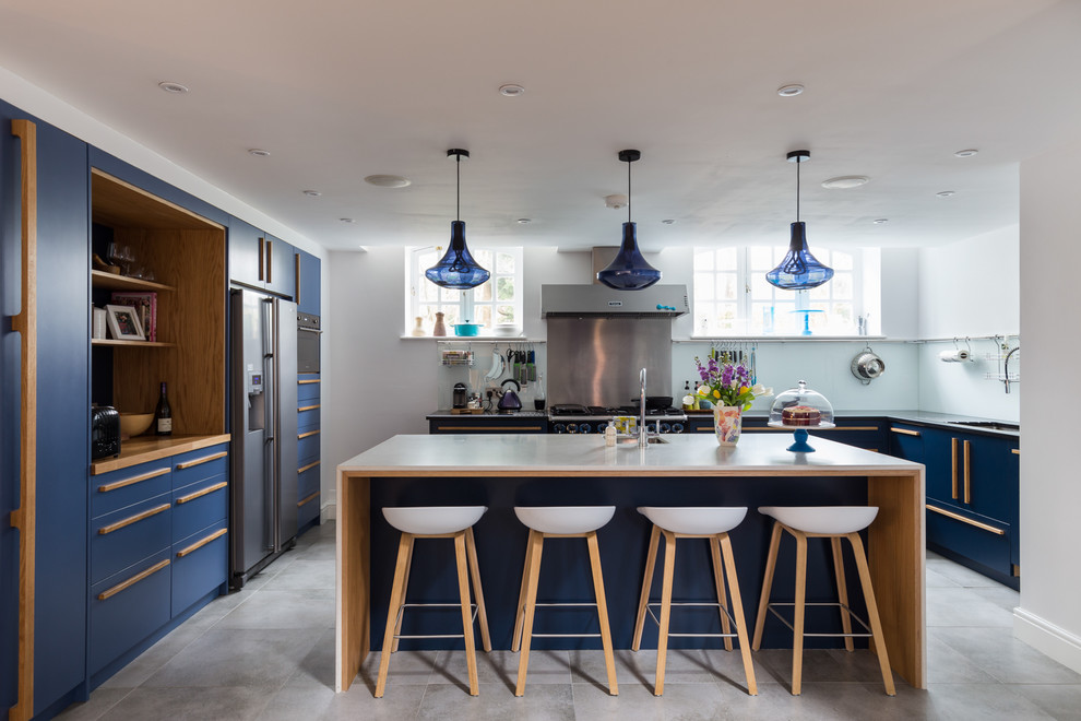 Photo of a large contemporary u-shaped separate kitchen in Surrey with flat-panel cabinets, blue cabinets, stainless steel appliances, with island, quartzite benchtops, ceramic floors and grey floor.
