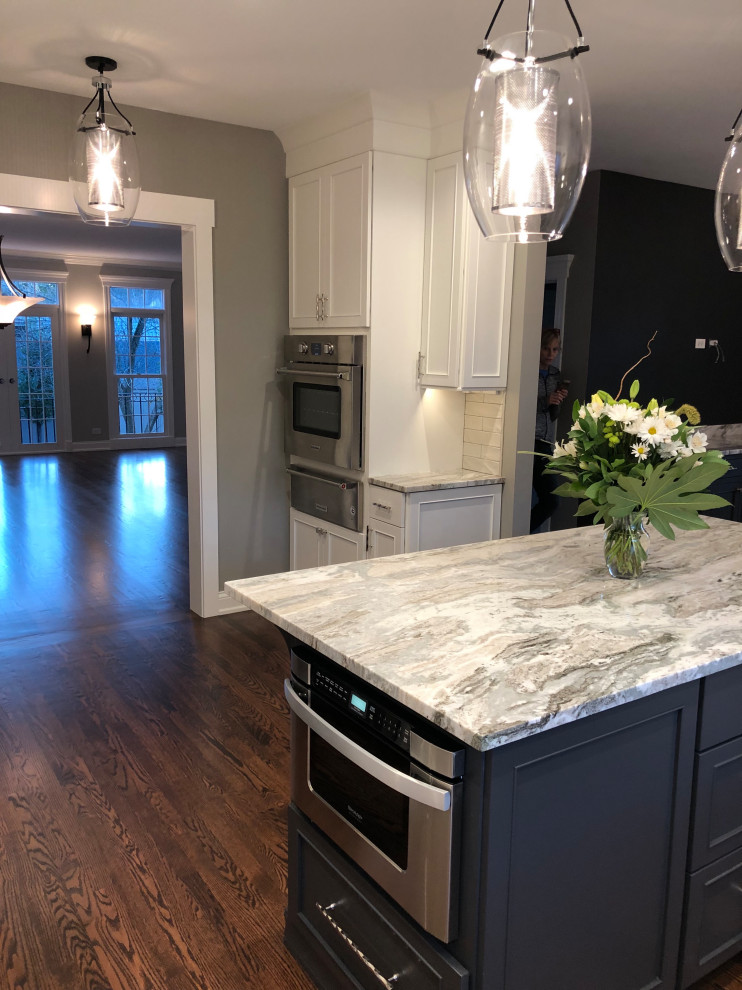 Eat-in kitchen - transitional eat-in kitchen idea in Chicago with white backsplash, stainless steel appliances and an island