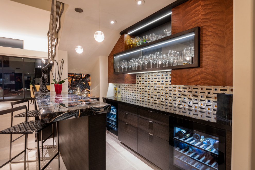 This is an example of a mid-sized contemporary galley seated home bar in Phoenix with flat-panel cabinets, dark wood cabinets, quartz benchtops, multi-coloured splashback, mosaic tile splashback, white floor and blue benchtop.