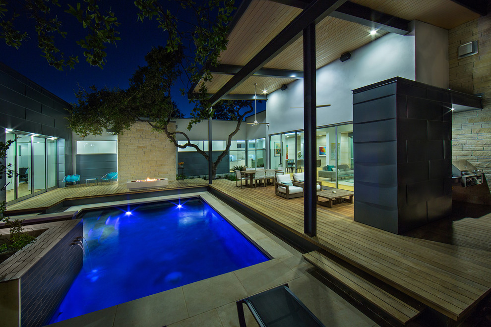 Inspiration for a small modern courtyard rectangular lap pool in Austin with a hot tub and natural stone pavers.