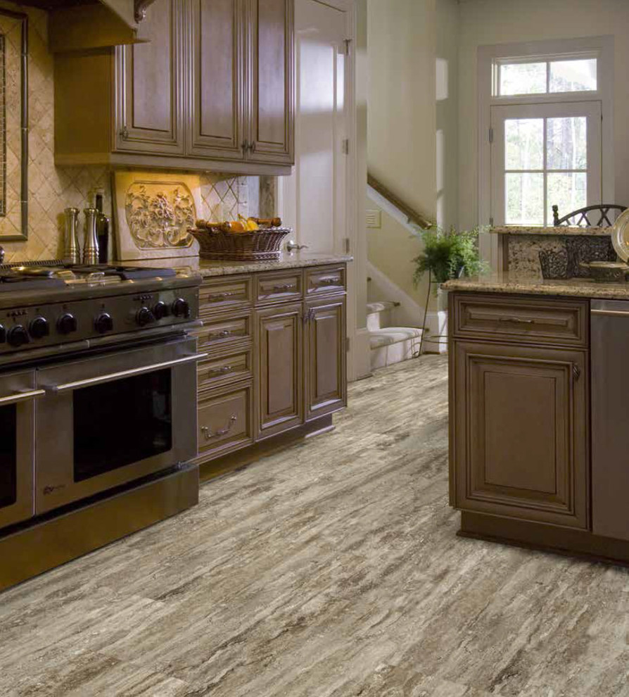Example of a classic vinyl floor kitchen design with raised-panel cabinets, brown cabinets, granite countertops, beige backsplash, ceramic backsplash and stainless steel appliances