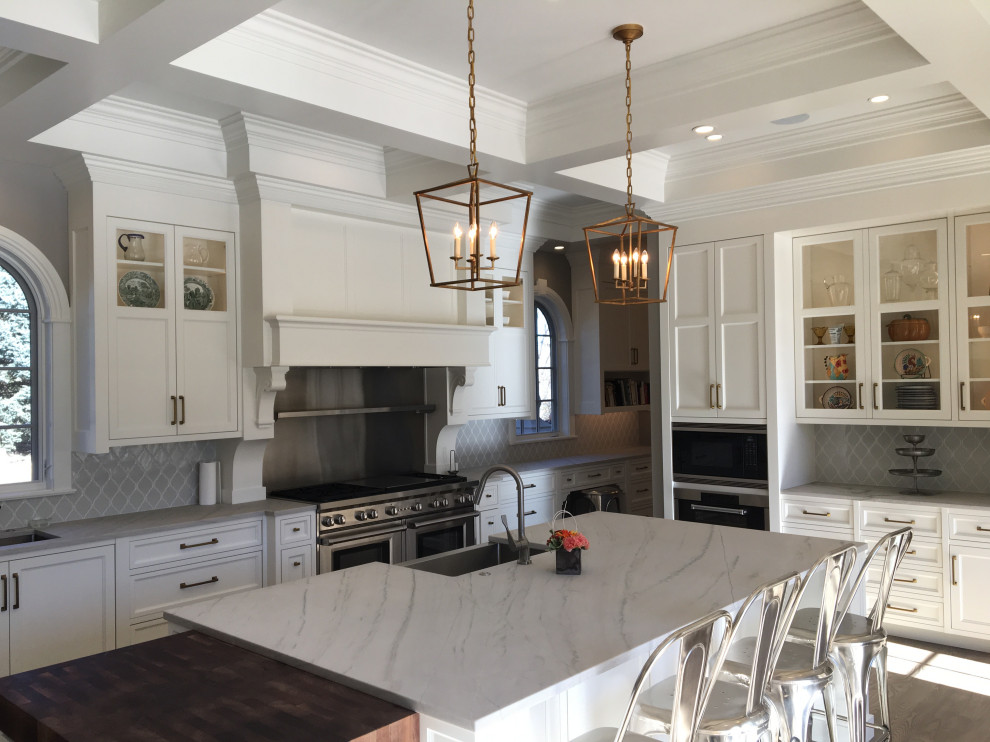 Photo of a large traditional u-shaped kitchen in Denver with a belfast sink, flat-panel cabinets, white cabinets, marble worktops, grey splashback, ceramic splashback, stainless steel appliances, dark hardwood flooring, an island, brown floors, white worktops and a coffered ceiling.