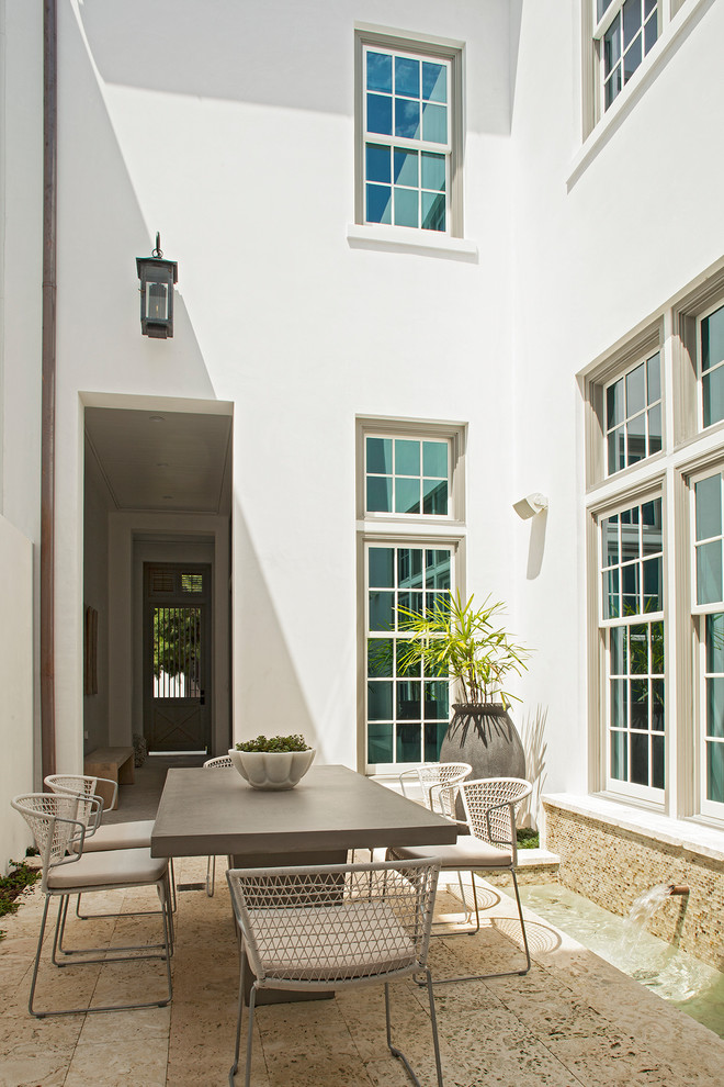 This is an example of a small contemporary courtyard patio in Nashville with a water feature, tile and no cover.