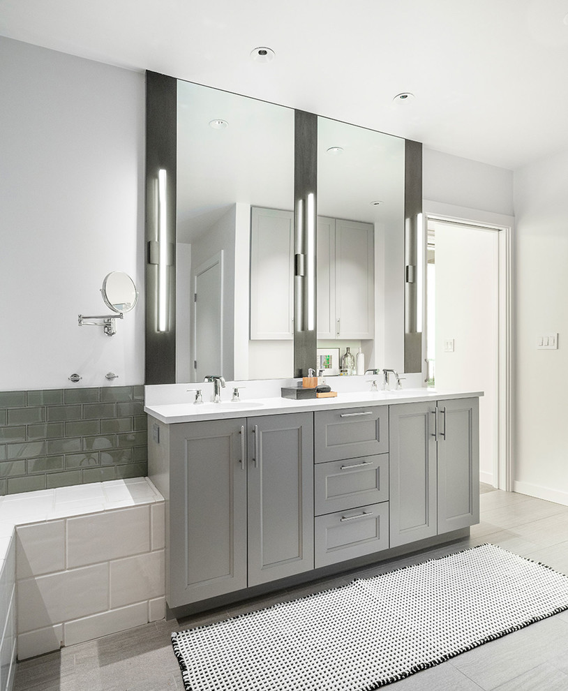 This is an example of a mid-sized industrial master bathroom in Seattle with grey cabinets, an undermount sink, engineered quartz benchtops, white benchtops, recessed-panel cabinets, gray tile, subway tile, white walls and grey floor.