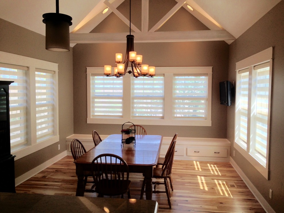 Example of a small transitional light wood floor and beige floor great room design with brown walls and no fireplace