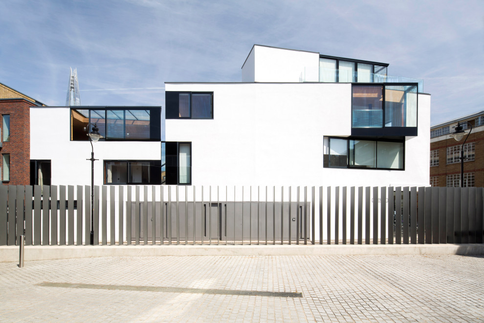 Inspiration for a large contemporary stucco white exterior in London with four or more storeys and a flat roof.