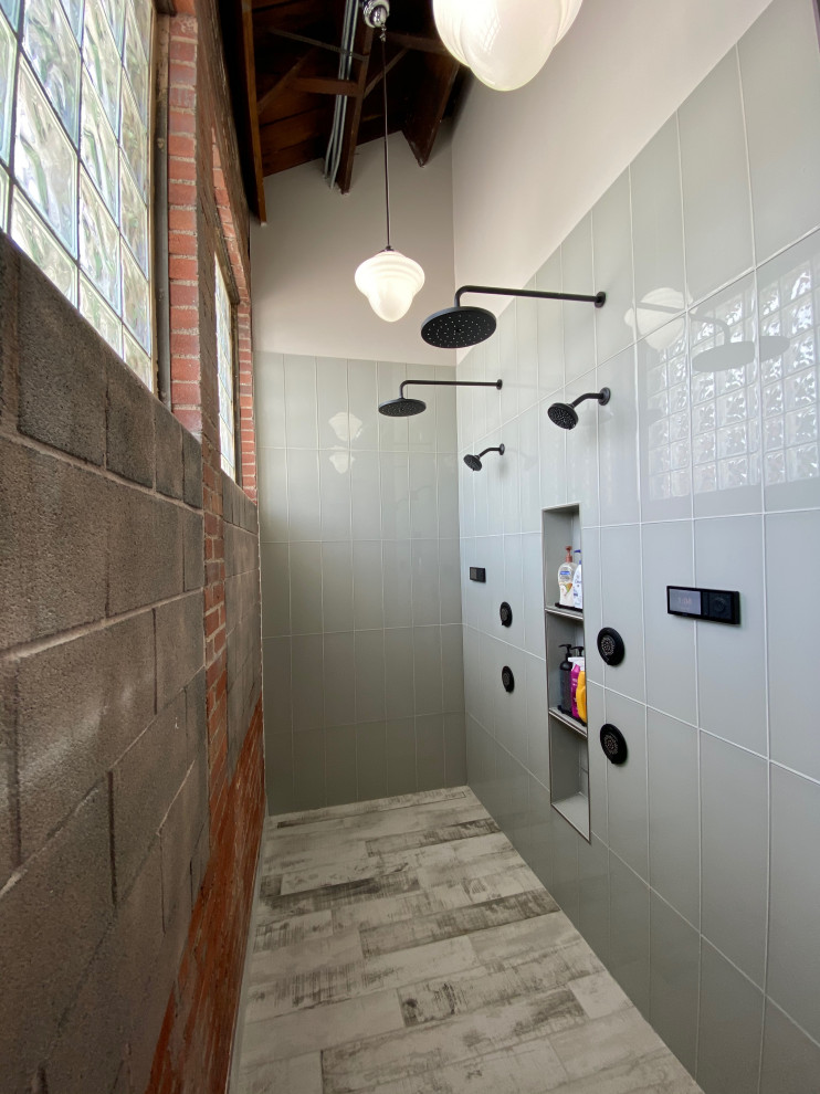 Photo of a large industrial master wet room bathroom in Kansas City with open cabinets, dark wood cabinets, gray tile, cement tile, grey walls, concrete floors, a vessel sink, wood benchtops, grey floor, an open shower, brown benchtops, a single vanity, a floating vanity, exposed beam and brick walls.
