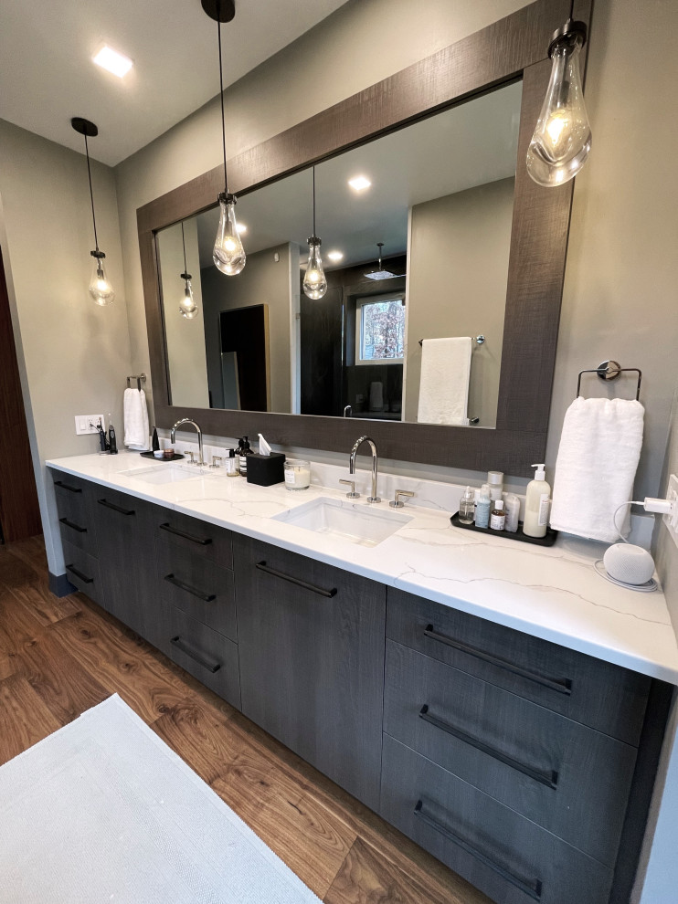 Inredning av ett modernt stort vit vitt en-suite badrum, med släta luckor, bruna skåp, en dubbeldusch, en bidé, stenhäll, grå väggar, mellanmörkt trägolv, ett undermonterad handfat, bänkskiva i kvarts, brunt golv och dusch med gångjärnsdörr