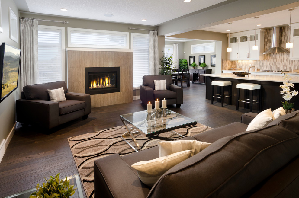 Inspiration for a mid-sized traditional open concept living room in Calgary with beige walls, dark hardwood floors, a standard fireplace, a tile fireplace surround and a wall-mounted tv.
