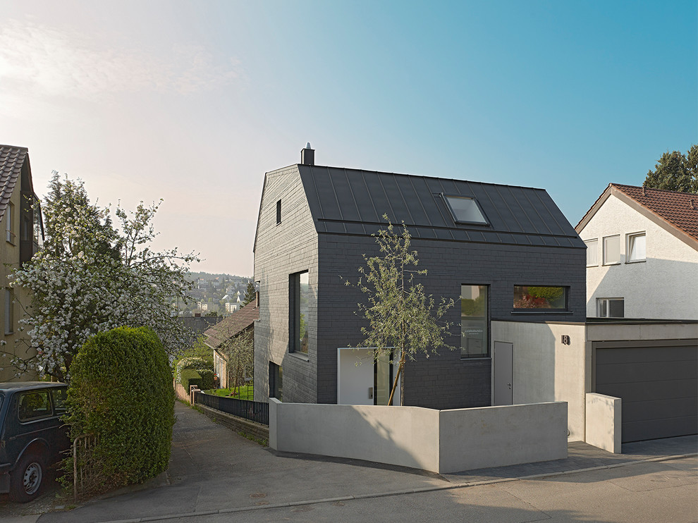 Mittelgroße, Dreistöckige Moderne Holzfassade Haus mit schwarzer Fassadenfarbe, Satteldach und schwarzem Dach in Stuttgart