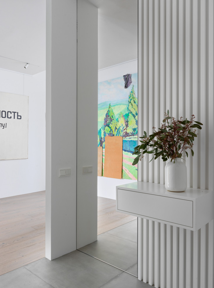 Imagen de vestíbulo actual de tamaño medio con paredes blancas, puerta simple, suelo gris, bandeja, panelado y suelo de baldosas de porcelana