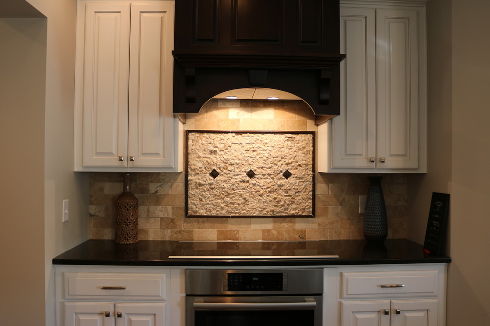 Kitchen - dark wood floor and brown floor kitchen idea in Columbus with stainless steel appliances and an island