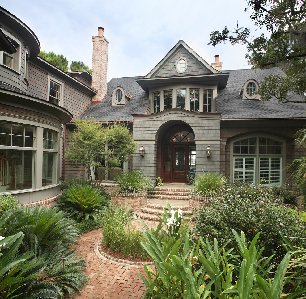 Large traditional two-storey grey house exterior in Charleston with wood siding, a gable roof and a shingle roof.