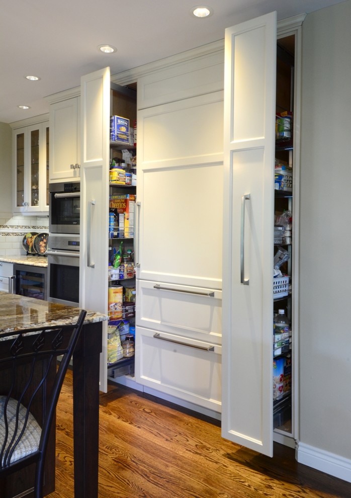 Example of a large transitional l-shaped medium tone wood floor open concept kitchen design in Seattle with a single-bowl sink, recessed-panel cabinets, white cabinets, granite countertops, beige backsplash, ceramic backsplash, stainless steel appliances and an island