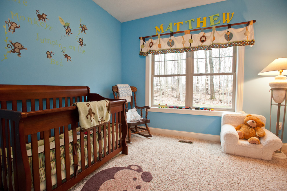 This is an example of a traditional nursery for boys in Cleveland with blue walls, carpet and beige floor.