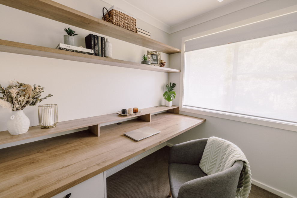 Kleines Modernes Arbeitszimmer mit Arbeitsplatz, weißer Wandfarbe, Teppichboden, Einbau-Schreibtisch und braunem Boden in Sonstige