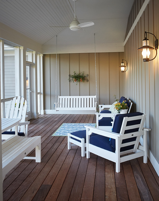 Cette photo montre un porche d'entrée de maison bord de mer avec une moustiquaire, une terrasse en bois et une extension de toiture.