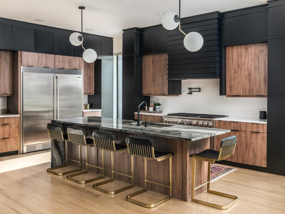 This is an example of a contemporary l-shaped kitchen in Nashville with an undermount sink, flat-panel cabinets, medium wood cabinets, white splashback, stainless steel appliances, medium hardwood floors, with island, brown floor and grey benchtop.