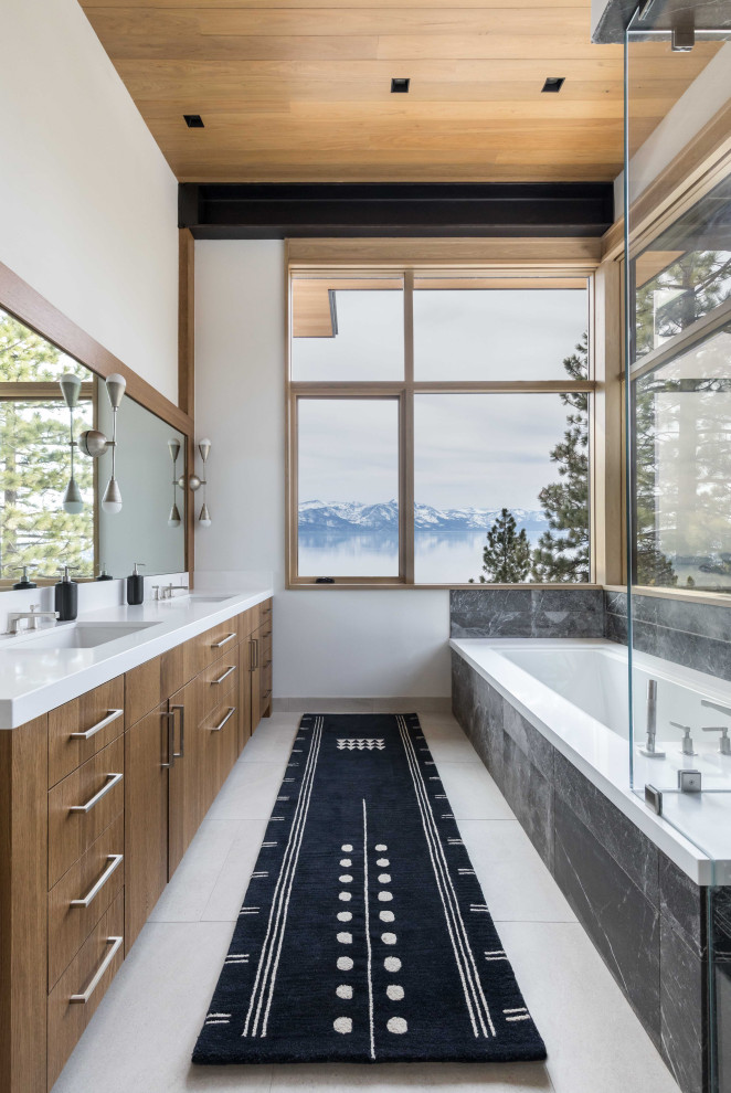 This is an example of a mid-sized country master bathroom in Other with flat-panel cabinets, medium wood cabinets, an undermount tub, black tile, stone tile, ceramic floors, an undermount sink, engineered quartz benchtops, white floor, white benchtops, a shower seat, a double vanity, a built-in vanity and wood.