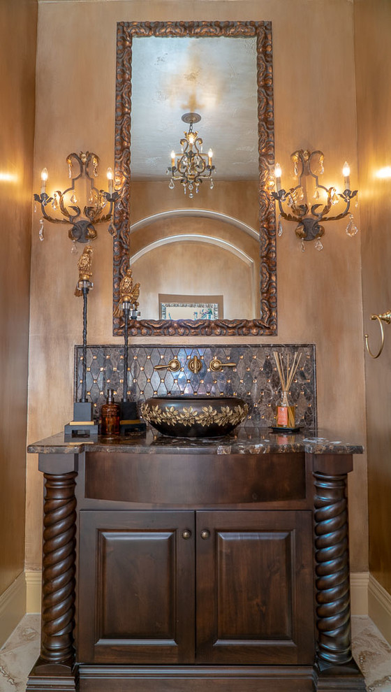 Inspiration for a mediterranean powder room in Austin with furniture-like cabinets, dark wood cabinets, brown walls, a vessel sink and brown benchtops.