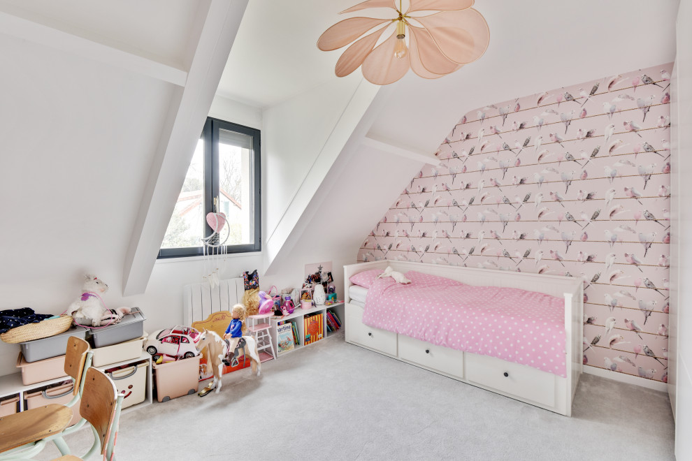 This is an example of a mid-sized contemporary kids' bedroom for kids 4-10 years old and girls in Paris with pink walls, carpet, beige floor and exposed beam.
