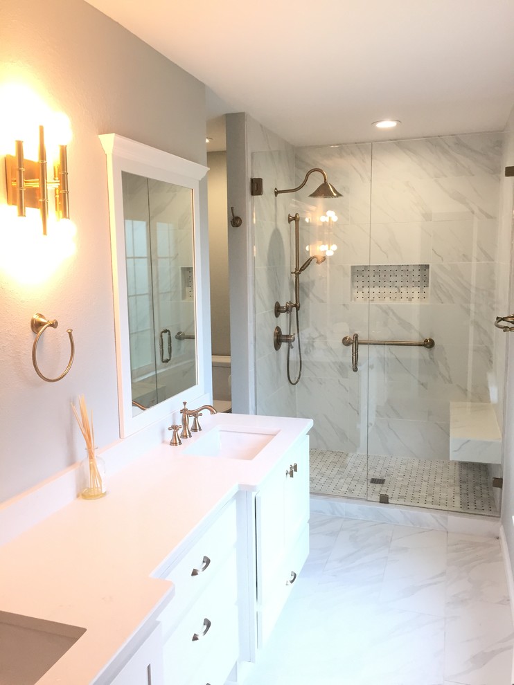 Photo of a large transitional master bathroom in Albuquerque with shaker cabinets, white cabinets, an alcove shower, white tile, marble, beige walls, marble floors, an undermount sink, marble benchtops, white floor, a hinged shower door and white benchtops.