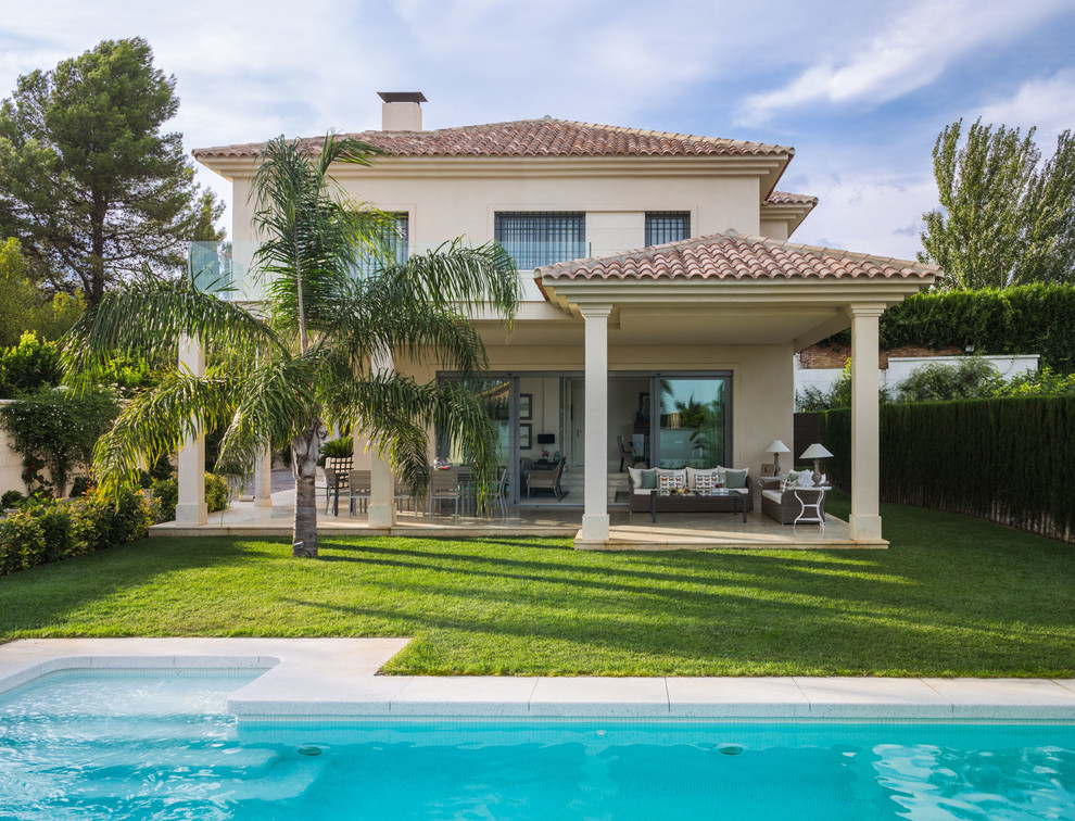 Inspiration for a mid-sized country two-storey stucco beige exterior in Malaga with a hip roof.