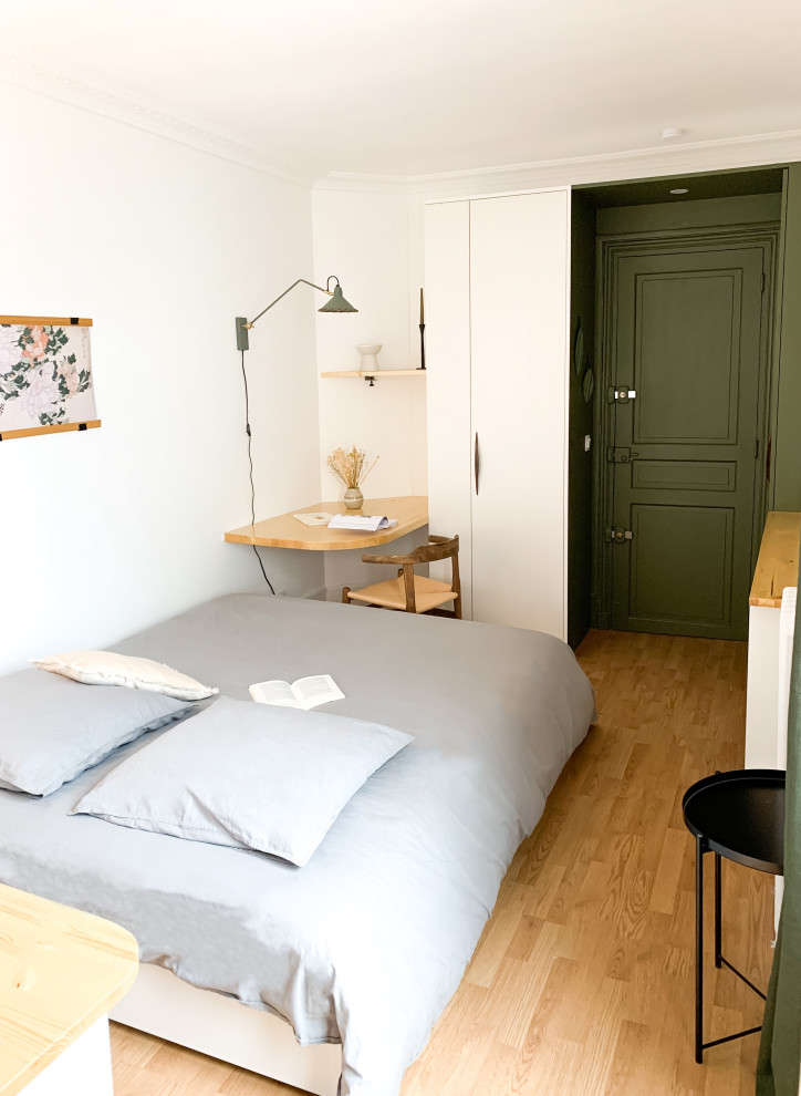 Photo of a small contemporary bedroom in Paris with laminate floors.