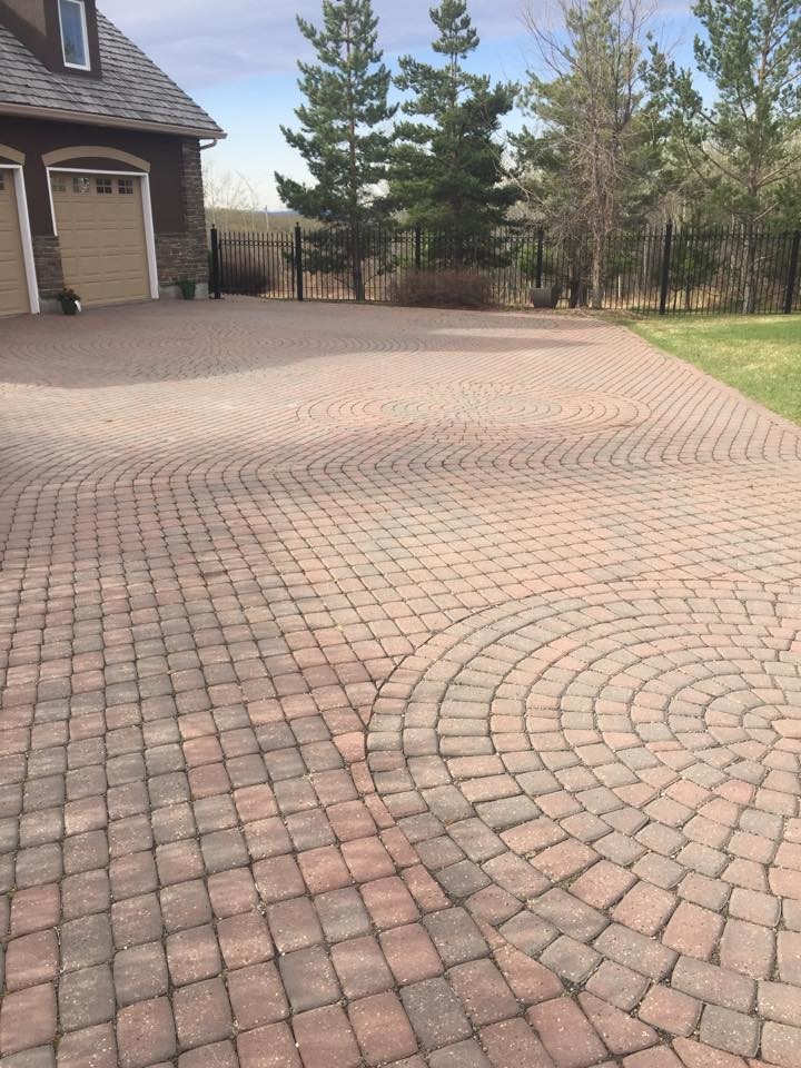 This is an example of a large transitional full sun front yard concrete paver driveway in Calgary.
