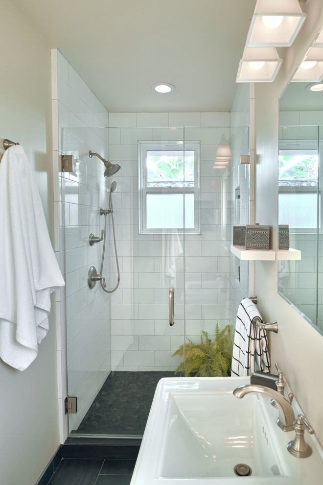 Inspiration for a small contemporary family bathroom in San Francisco with white cabinets, an alcove shower, a one-piece toilet, white tiles, ceramic tiles, white walls, porcelain flooring, a pedestal sink, black floors, a hinged door, a wall niche, a single sink and a freestanding vanity unit.