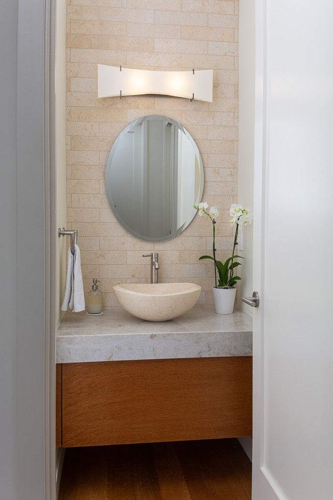 Inspiration for a cloakroom in Los Angeles with flat-panel cabinets, brown cabinets, a one-piece toilet, beige tiles, stone tiles, white walls, dark hardwood flooring, a vessel sink, quartz worktops, brown floors, beige worktops and a floating vanity unit.