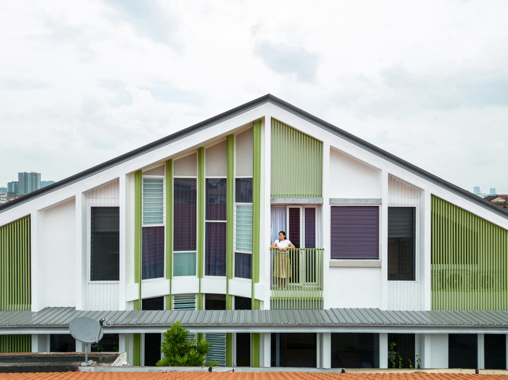 Réalisation d'une façade de maison blanche asiatique en briques peintes de taille moyenne et à un étage avec un toit à deux pans, un toit en métal et un toit gris.