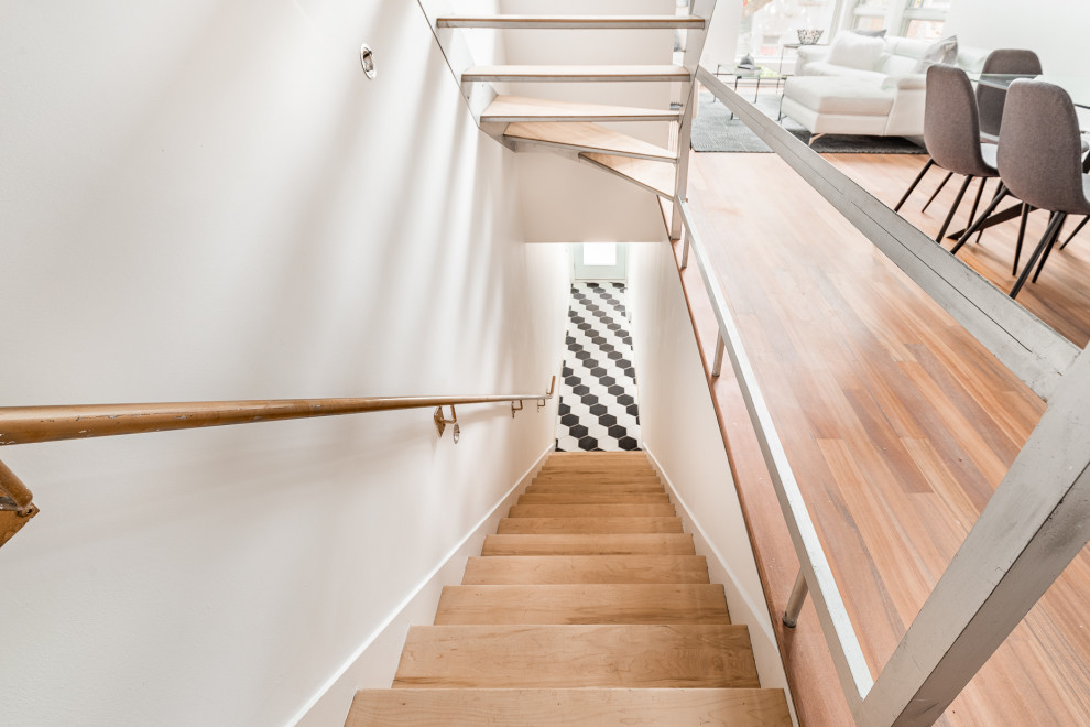Réalisation d'un escalier sans contremarche droit minimaliste de taille moyenne avec des marches en bois et un garde-corps en métal.