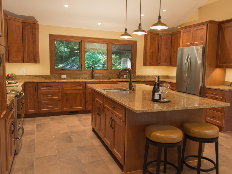 Photo of a large arts and crafts u-shaped eat-in kitchen in DC Metro with a double-bowl sink, shaker cabinets, medium wood cabinets, granite benchtops, stainless steel appliances, with island and beige benchtop.