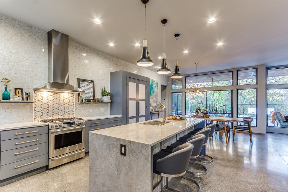 Design ideas for a mid-sized transitional l-shaped eat-in kitchen in Nashville with an undermount sink, flat-panel cabinets, grey cabinets, quartzite benchtops, grey splashback, stainless steel appliances, concrete floors, with island and mosaic tile splashback.