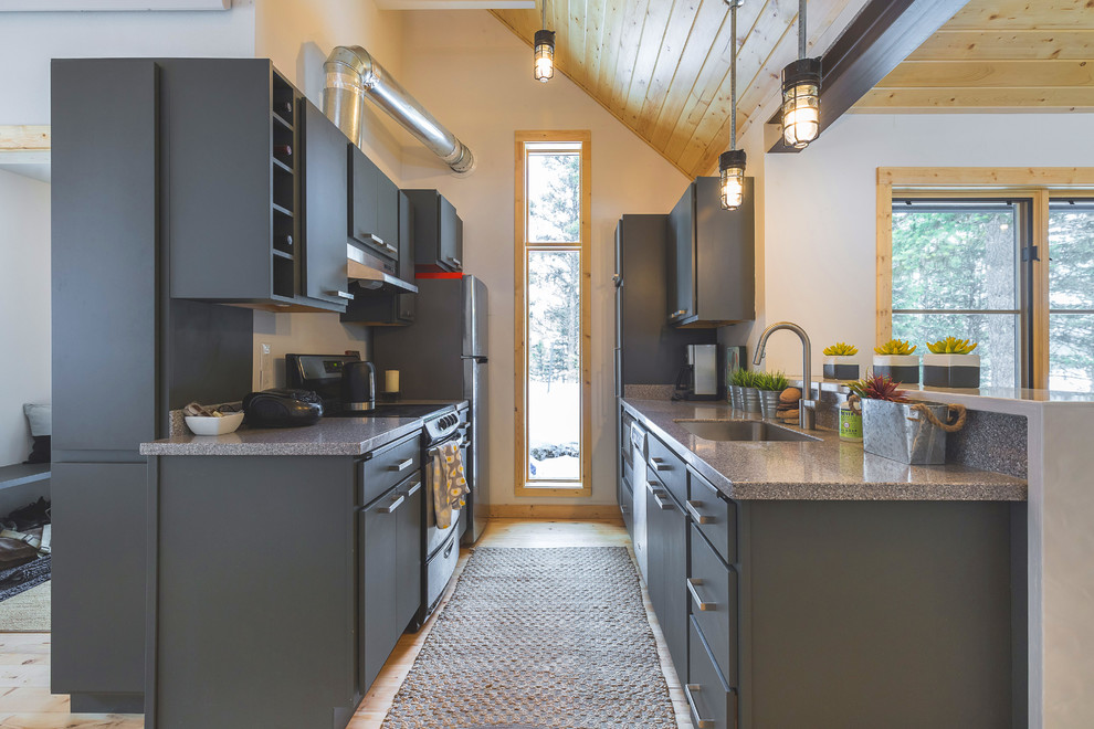 Example of a mountain style galley medium tone wood floor and brown floor kitchen design with an undermount sink, flat-panel cabinets, gray cabinets, a peninsula and gray countertops