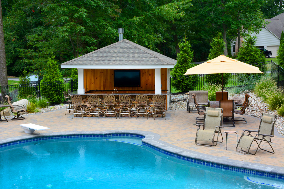 Example of a mid-sized backyard concrete paver and custom-shaped pool design in Baltimore