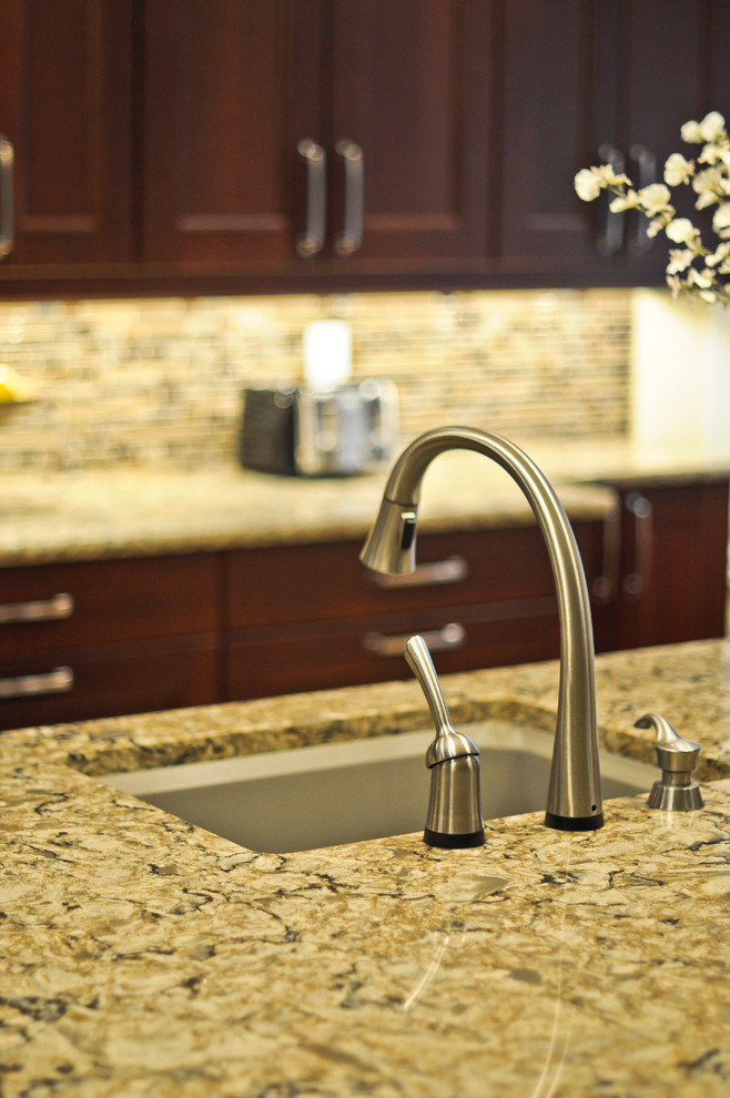 Example of a transitional cork floor kitchen design in Ottawa with recessed-panel cabinets, brown cabinets, quartzite countertops, multicolored backsplash, mosaic tile backsplash, stainless steel appliances and an island