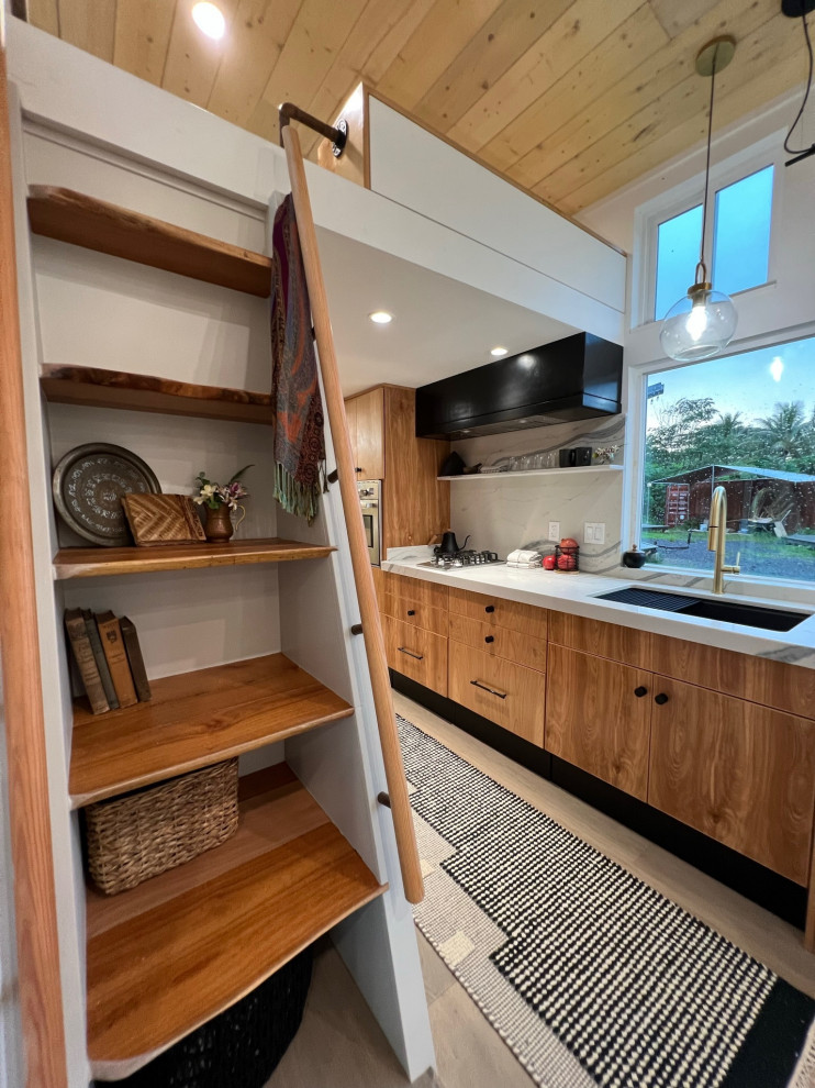 Inspiration for a mid-sized contemporary galley open plan kitchen in Hawaii with an undermount sink, flat-panel cabinets, medium wood cabinets, granite benchtops, white splashback, granite splashback, stainless steel appliances, light hardwood floors, no island, beige floor, white benchtop and timber.