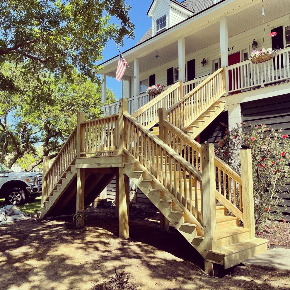 This is an example of a mid-sized beach style wood staircase in Charleston with wood risers, wood railing and wood walls.