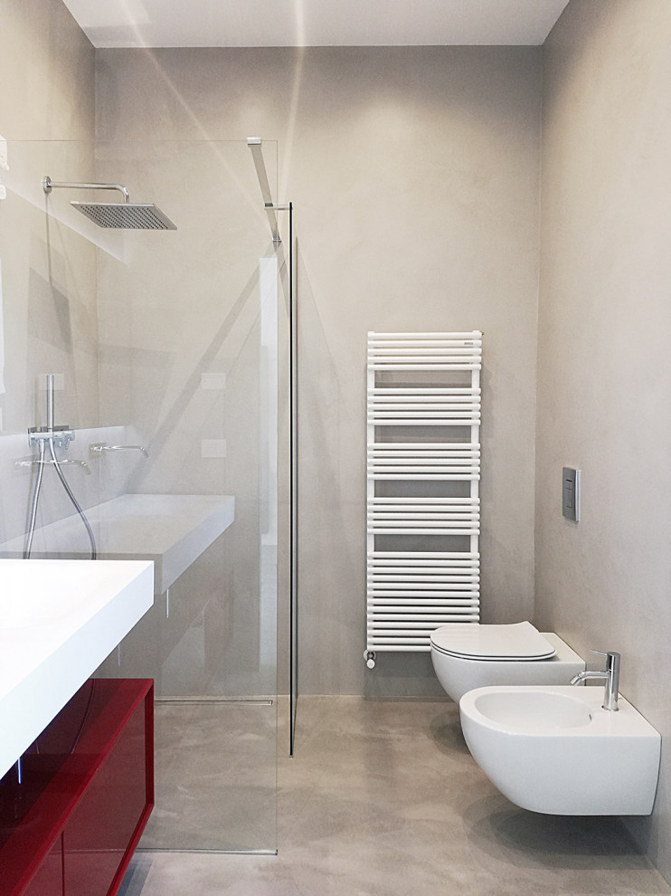 Inspiration for a mid-sized contemporary master bathroom in Venice with flat-panel cabinets, red cabinets, a curbless shower, a wall-mount toilet, grey walls, concrete floors, a vessel sink, solid surface benchtops, grey floor, an open shower, a laundry, a double vanity and a floating vanity.