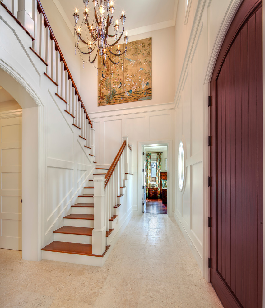 This is an example of a tropical wood u-shaped staircase in Tampa with painted wood risers and wood railing.