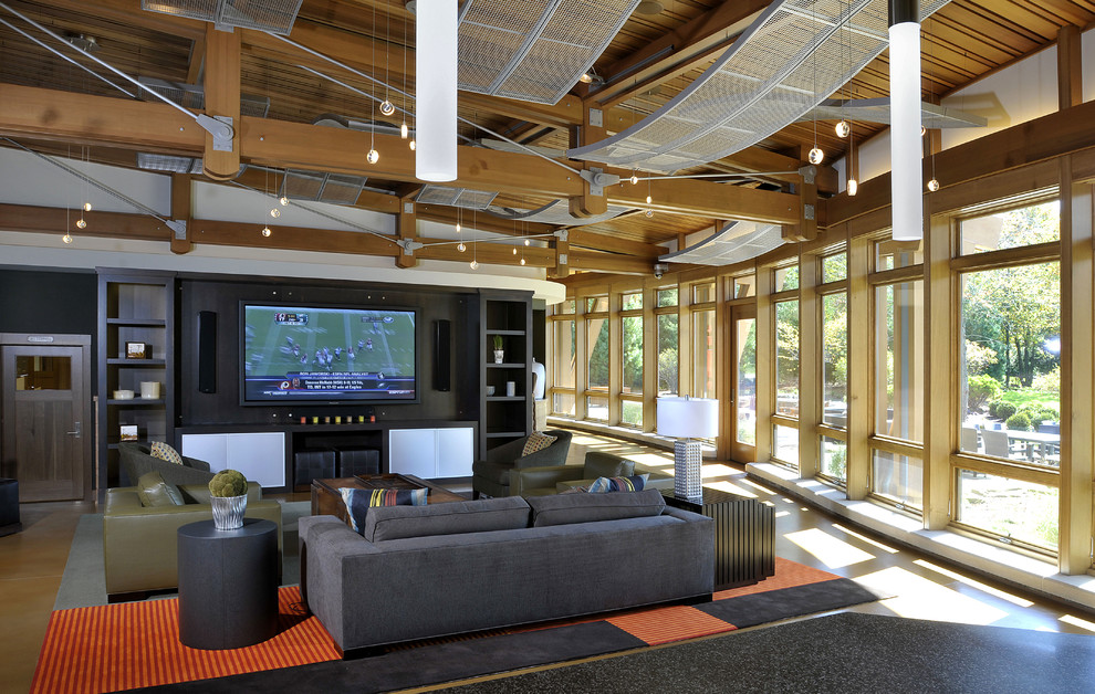 This is an example of a contemporary open concept home theatre in Grand Rapids with a wall-mounted tv.