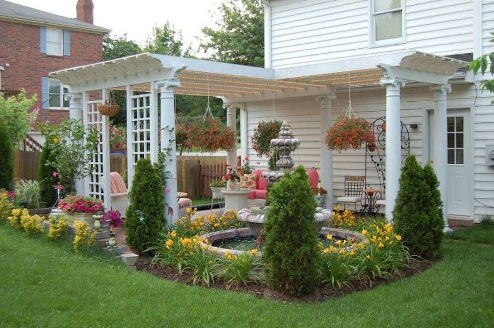 Example of a mid-sized transitional backyard patio fountain design with a pergola