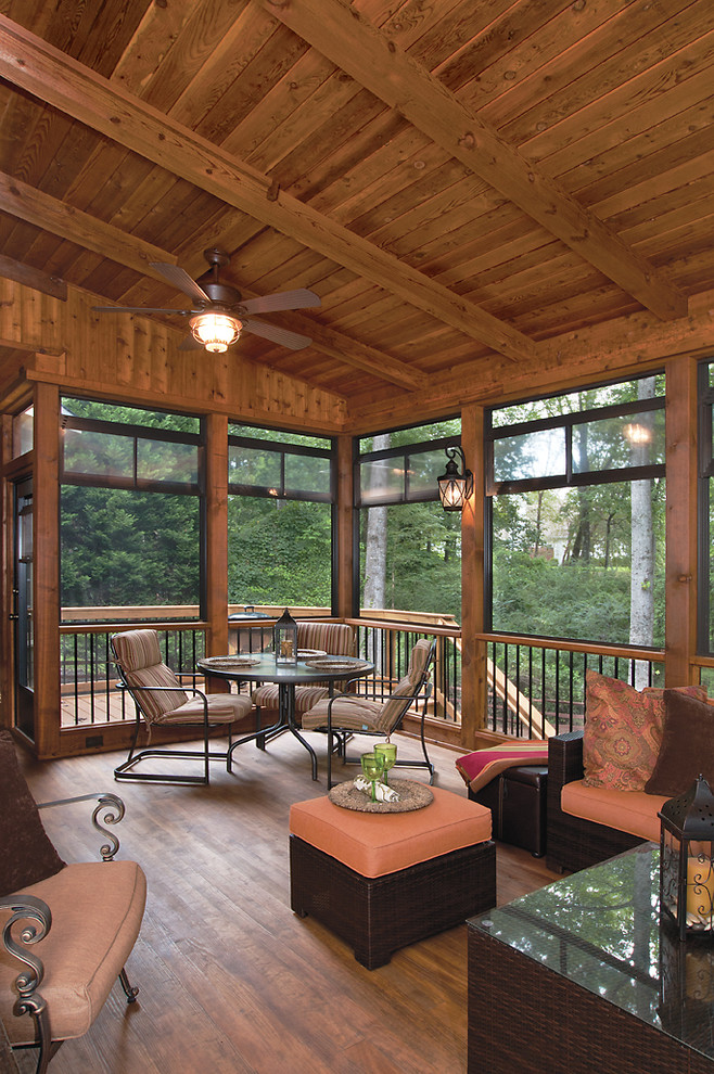 This is an example of a large transitional screened-in back porch design in Atlanta with decking and a roof extension.