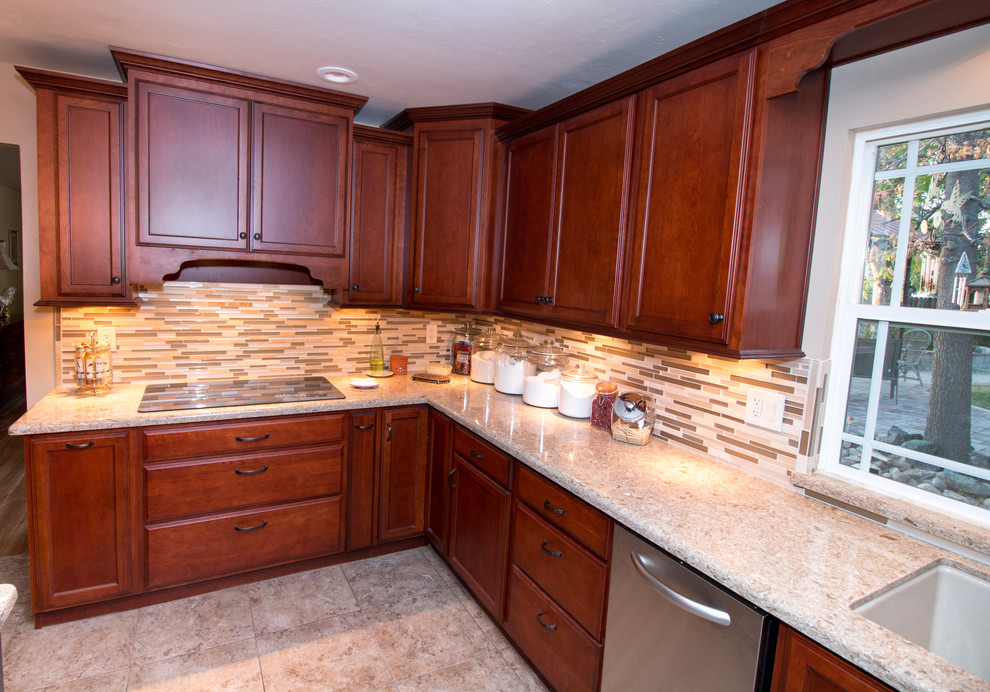 Inspiration for a large transitional u-shaped porcelain tile kitchen remodel with an undermount sink, flat-panel cabinets, medium tone wood cabinets, quartz countertops, beige backsplash, mosaic tile backsplash, stainless steel appliances and an island