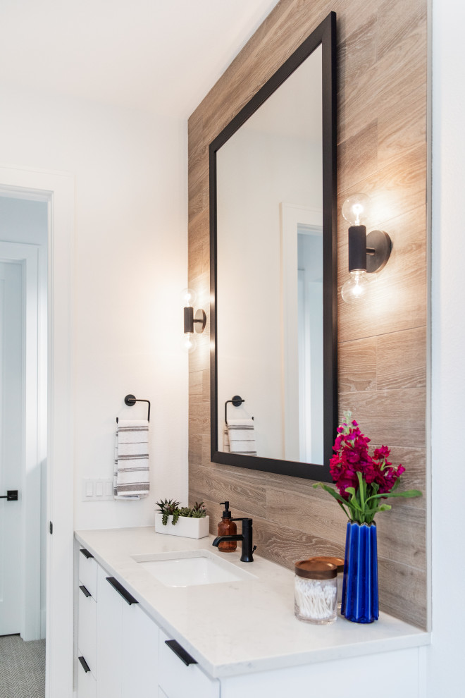 This is an example of a mid-sized modern kids bathroom in Austin with a drop-in tub, a shower/bathtub combo, a two-piece toilet, brown tile, porcelain tile, brown walls, ceramic floors, a drop-in sink, granite benchtops, grey floor, a shower curtain and white benchtops.